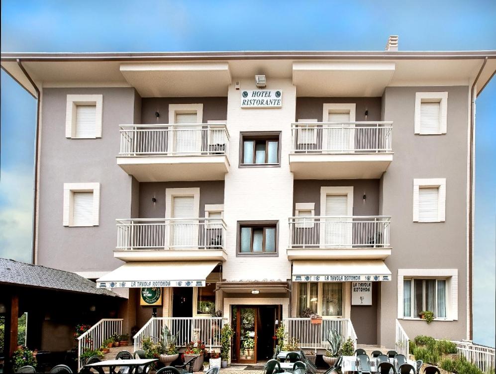 a building with tables and chairs in front of it at Hotel La Tavola Rotonda in Assisi