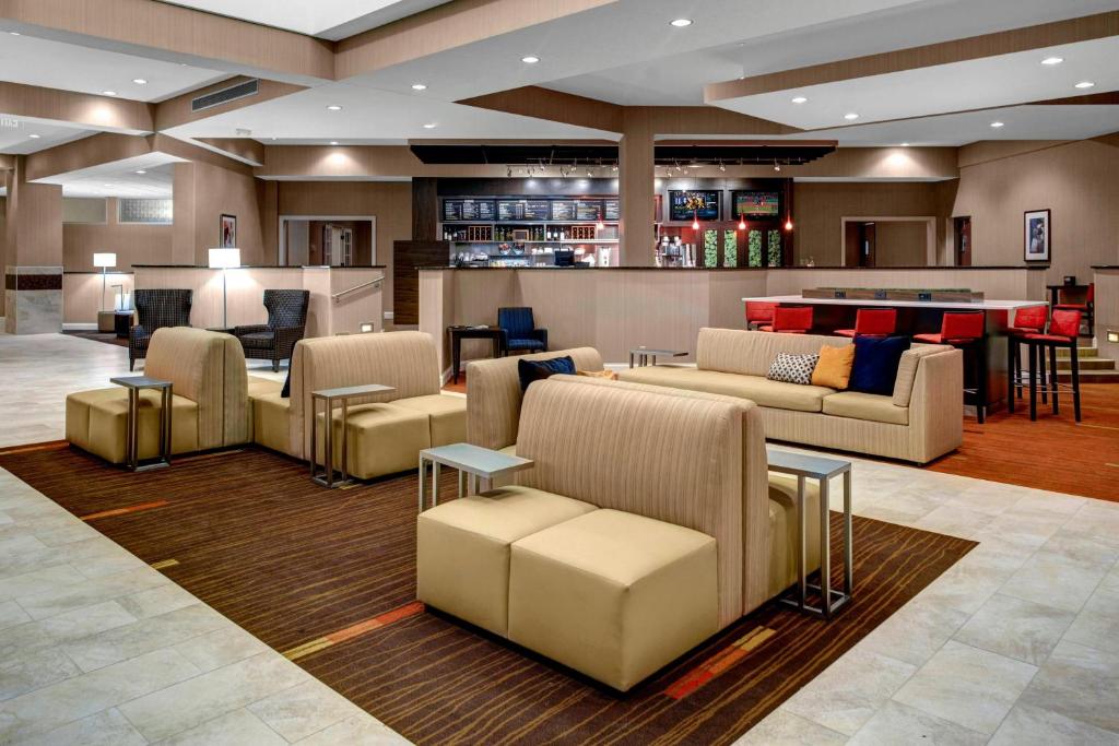 a lobby of a hotel with couches and a bar at Courtyard by Marriott St. Cloud in Saint Cloud