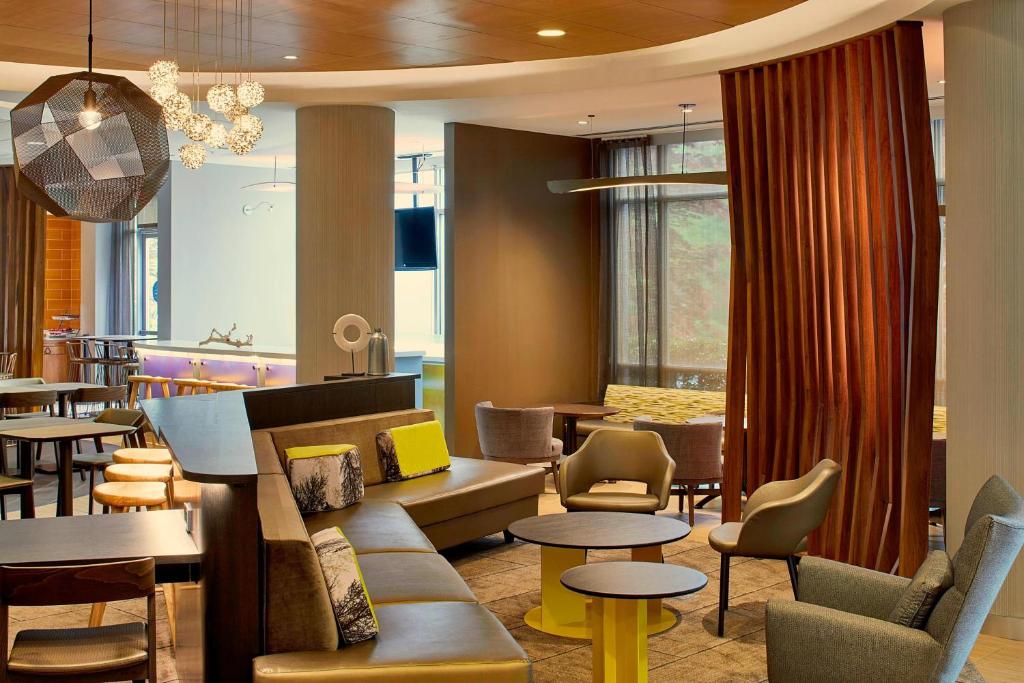 a lobby with tables and chairs and a restaurant at SpringHill Suites by Marriott Atlanta Airport Gateway in Atlanta