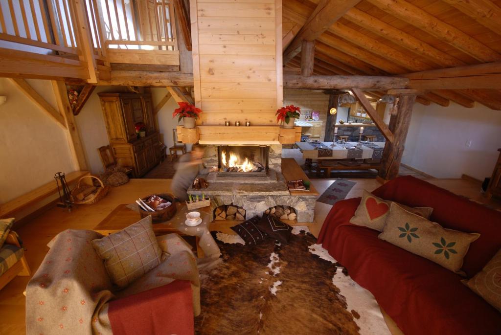 een woonkamer met een open haard bij Chalet des Laix in La Rosière