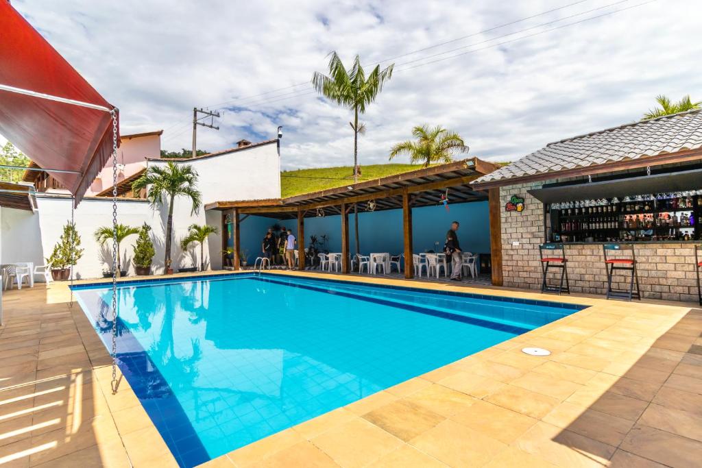 a swimming pool in front of a house at Kings International Hotel in Rio das Flores