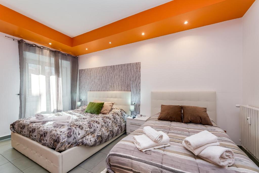 2 letti in una camera da letto con soffitto arancione di Lovely ROOMS VATICAN a Roma