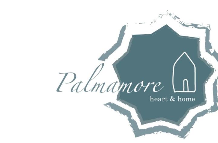 um logótipo de uma casa com uma porta e uma janela em Palmamore em Palmanova