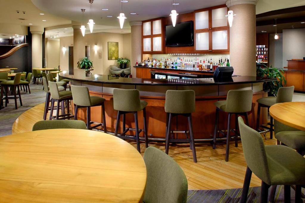 a bar in a restaurant with tables and chairs at Courtyard Reading Wyomissing in Reading