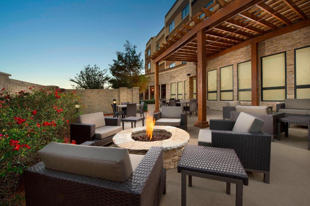 een patio met een vuurplaats en stoelen en een gebouw bij Courtyard by Marriott Wichita Falls in Wichita Falls