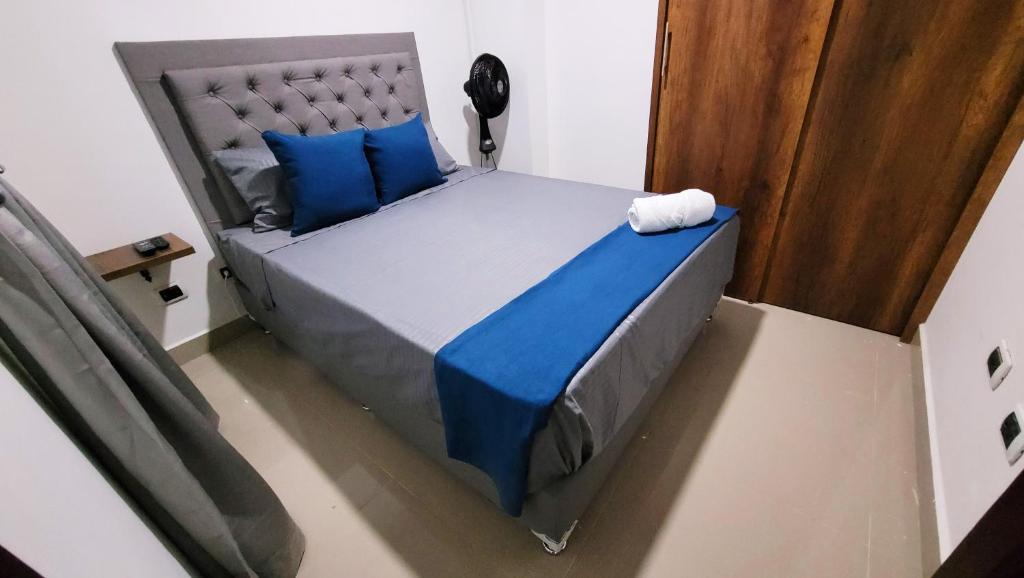 an overhead view of a bed with blue pillows at ANDALIVING NIQUIA APARTAMENTO in Bello