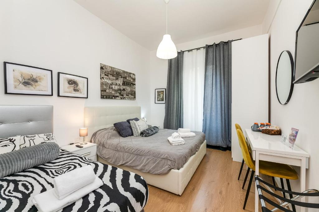 Un dormitorio con una cama y un escritorio y un escritorio. en Julius Caesar Home, en Roma