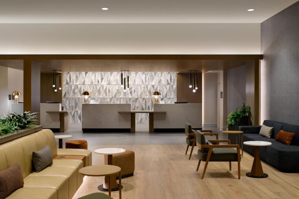 a lobby with couches and tables and a kitchen at Sheraton Park Hotel at the Anaheim Resort in Anaheim