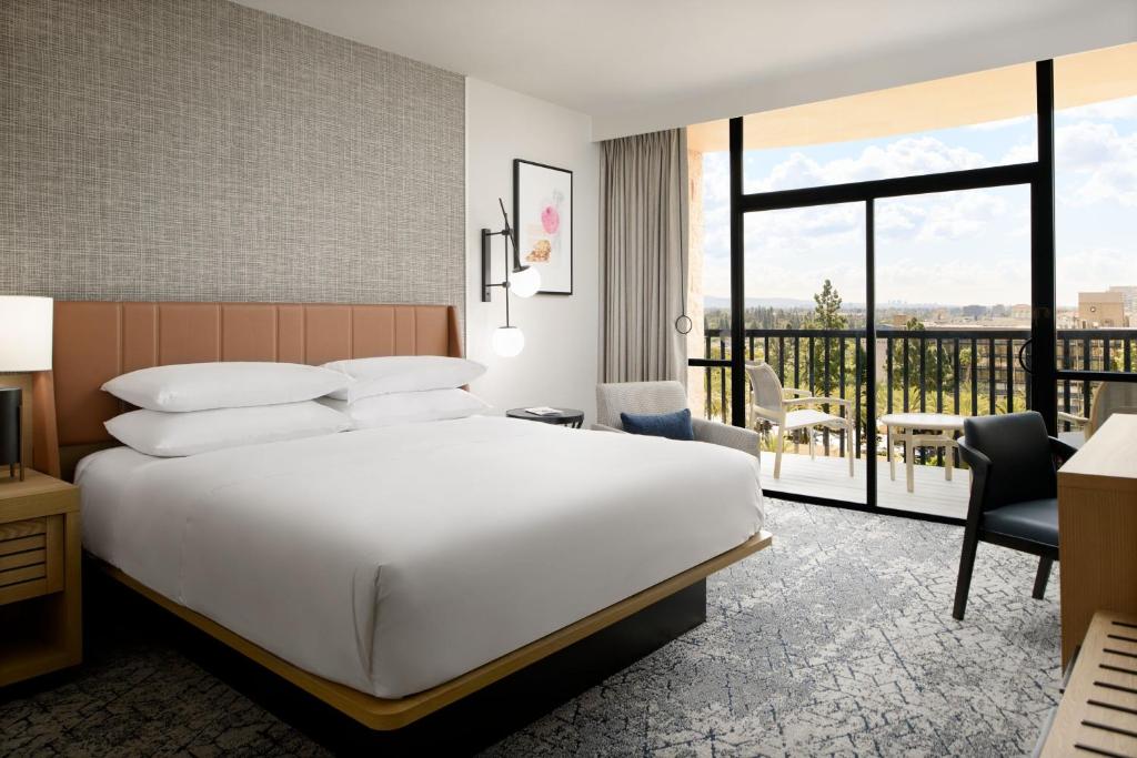 a hotel room with a bed and a balcony at Sheraton Park Hotel at the Anaheim Resort in Anaheim