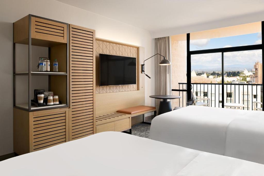 a hotel room with two beds and a television at Sheraton Park Hotel at the Anaheim Resort in Anaheim