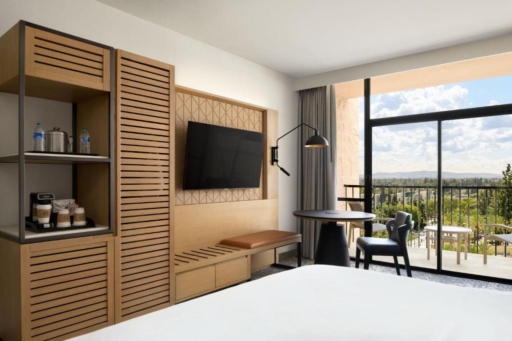 a bedroom with a bed and a television and a table at Sheraton Park Hotel at the Anaheim Resort in Anaheim