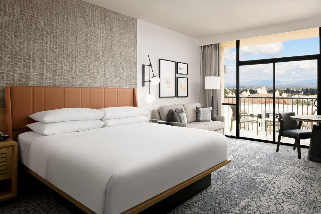 a hotel room with a bed and a balcony at Sheraton Park Hotel at the Anaheim Resort in Anaheim