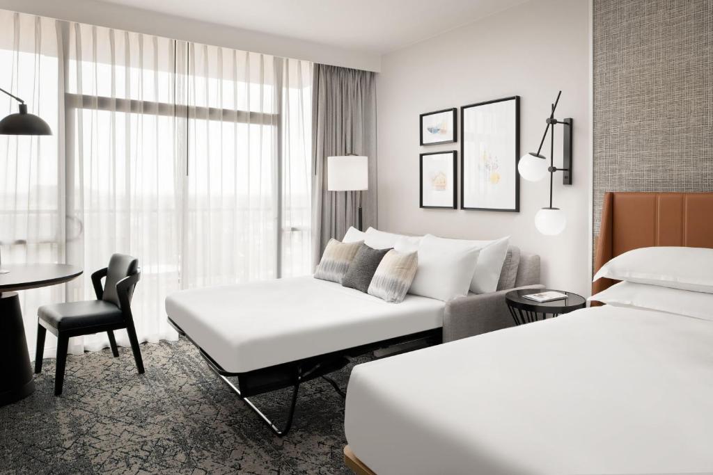 a hotel room with two beds and a couch at Sheraton Park Hotel at the Anaheim Resort in Anaheim