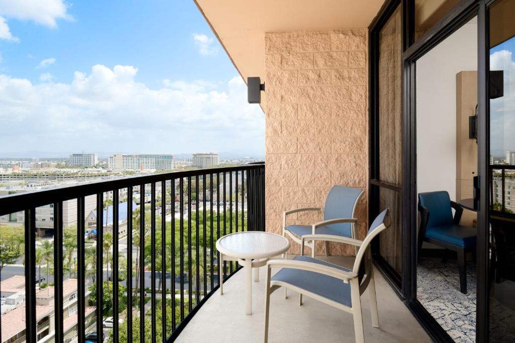 a balcony with chairs and a table and a view at Sheraton Park Hotel at the Anaheim Resort in Anaheim