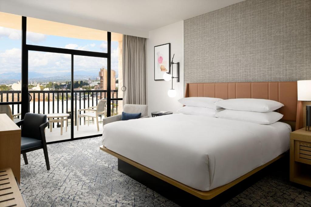 a hotel room with a bed and a balcony at Sheraton Park Hotel at the Anaheim Resort in Anaheim