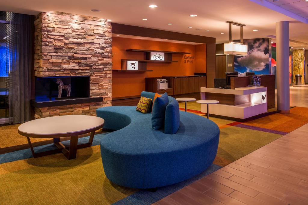 a living room with a blue couch and a fireplace at Fairfield Inn & Suites by Marriott St. Louis Westport in Maryland Heights