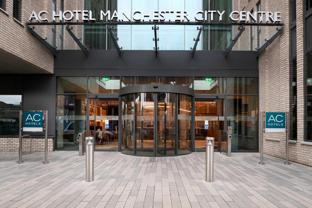 un bâtiment avec une entrée tournante dans le centre-ville d'un gérant d'hôtel dans l'établissement AC Hotel by Marriott Manchester City Centre, à Manchester