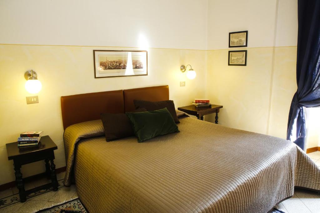 um quarto com uma cama com duas mesas e dois candeeiros em Albergo Garisenda em Bolonha