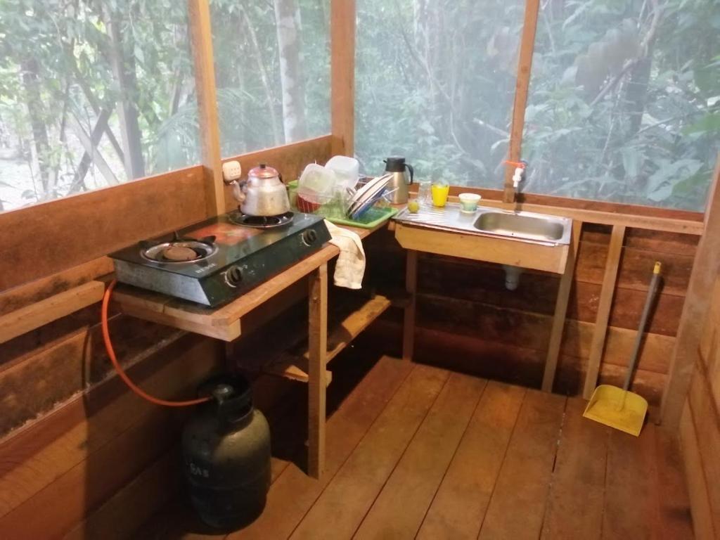 a kitchen with a stove and a sink in a room at Tambopata River in Puerto Maldonado