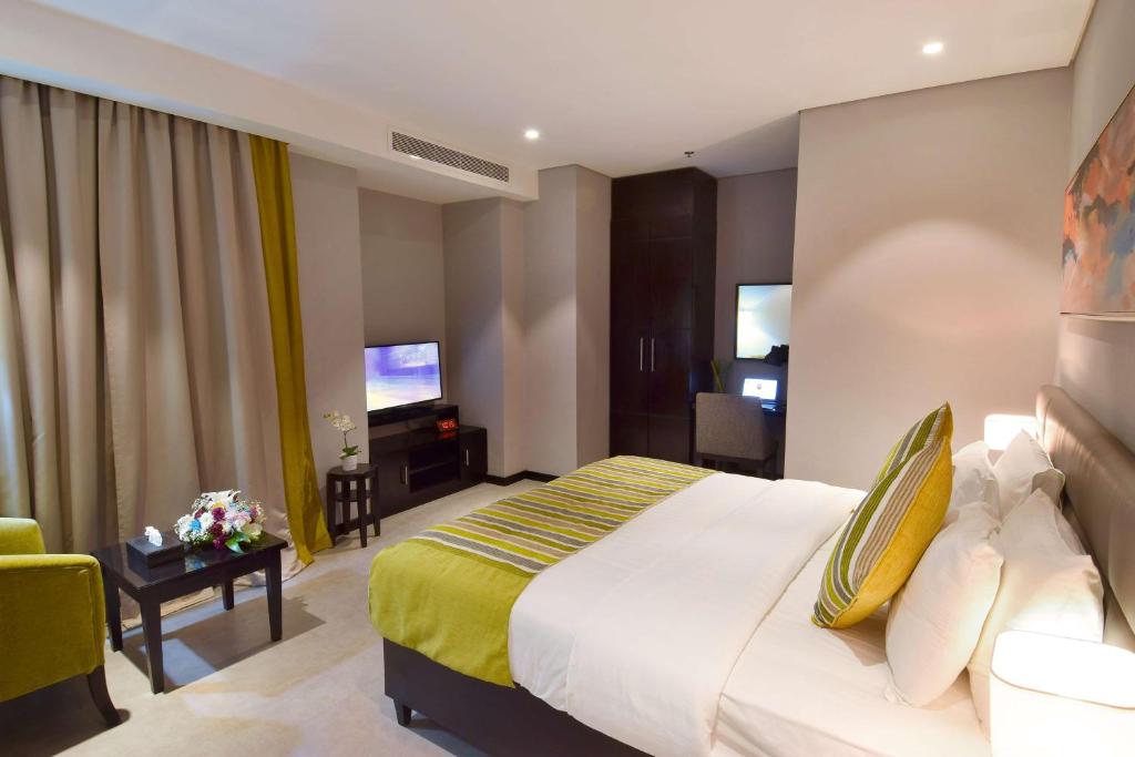 a hotel room with a bed and a living room at Best Western Plus Fursan in Riyadh