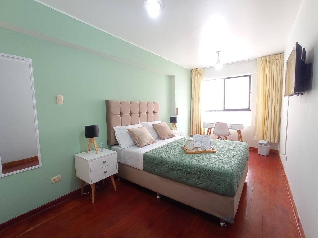 1 dormitorio con 1 cama grande con manta verde en Habi baño Compartido Grimaldo 1, en Lima