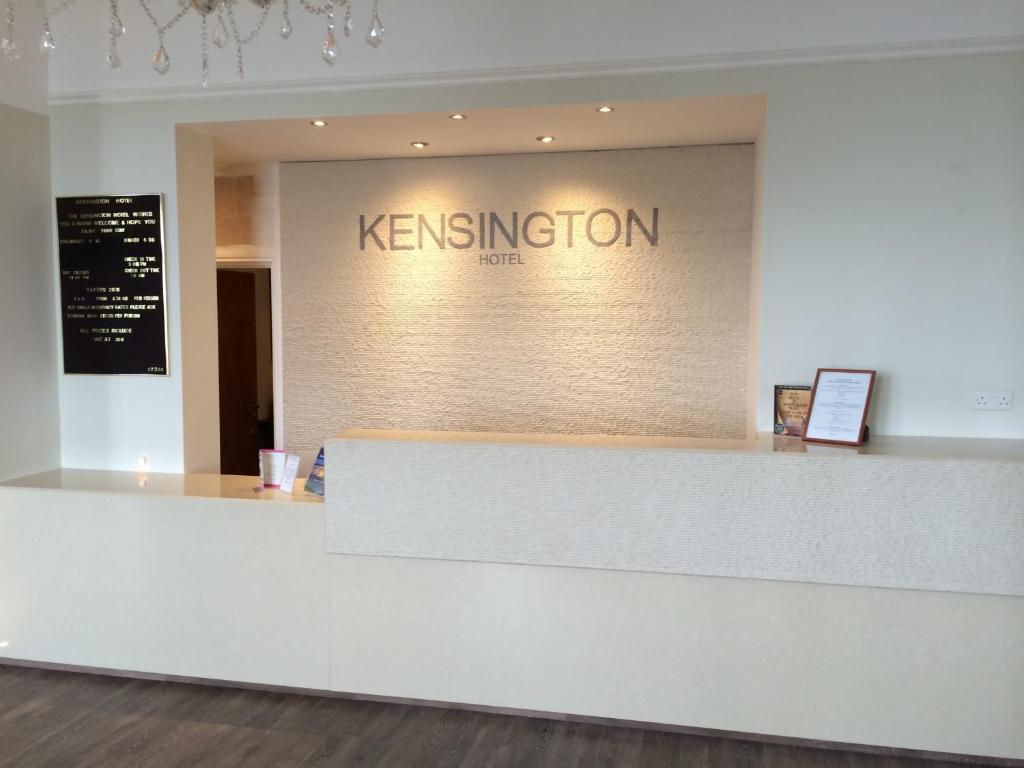 a reception counter with the words kisenvention on a wall at Kensington Hotel in Llandudno