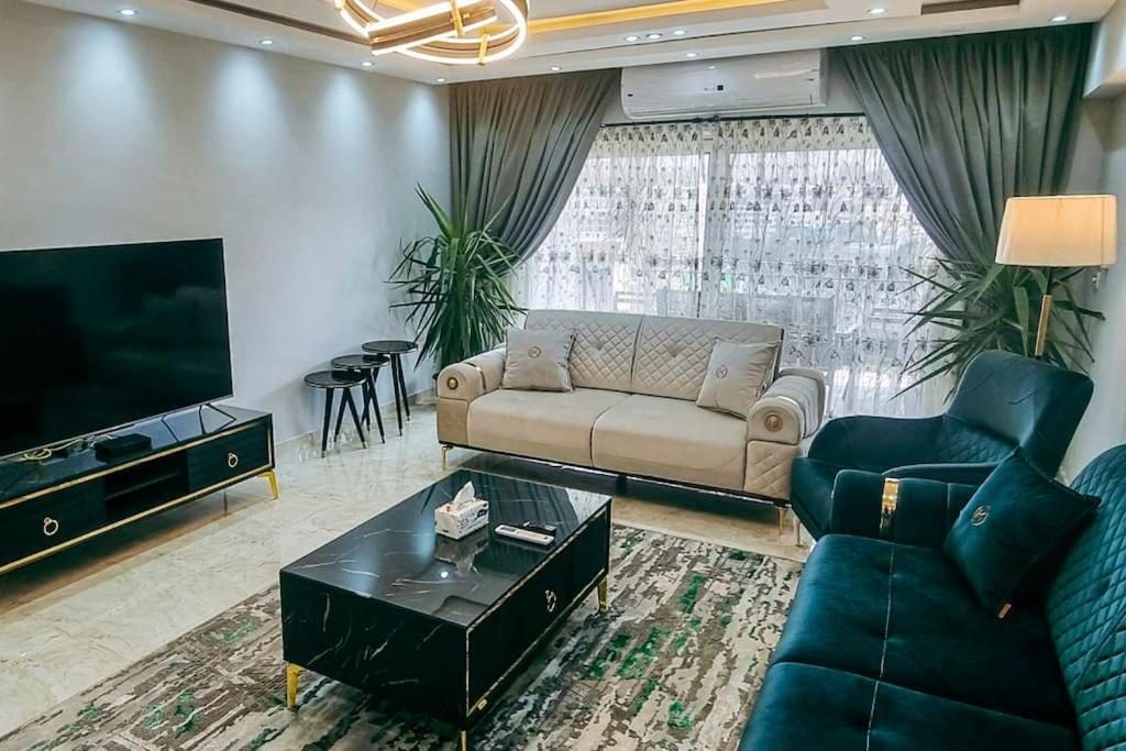 a living room with a couch and a tv at Luxury VIP apartment in Cairo