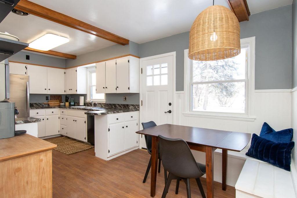 una cocina con armarios blancos y una mesa con sillas. en NEW Charming Home in the Heart of North Fargo, en Fargo