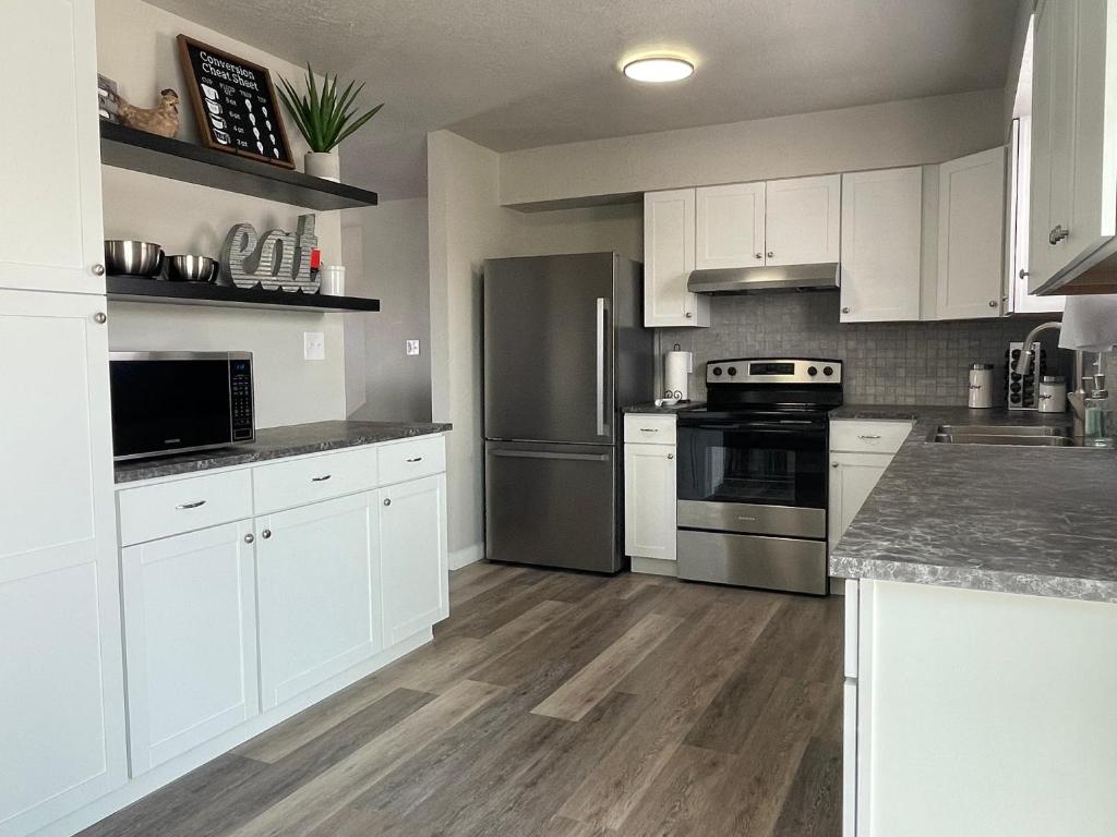 a kitchen with white cabinets and stainless steel appliances at Ray's Place in Roy