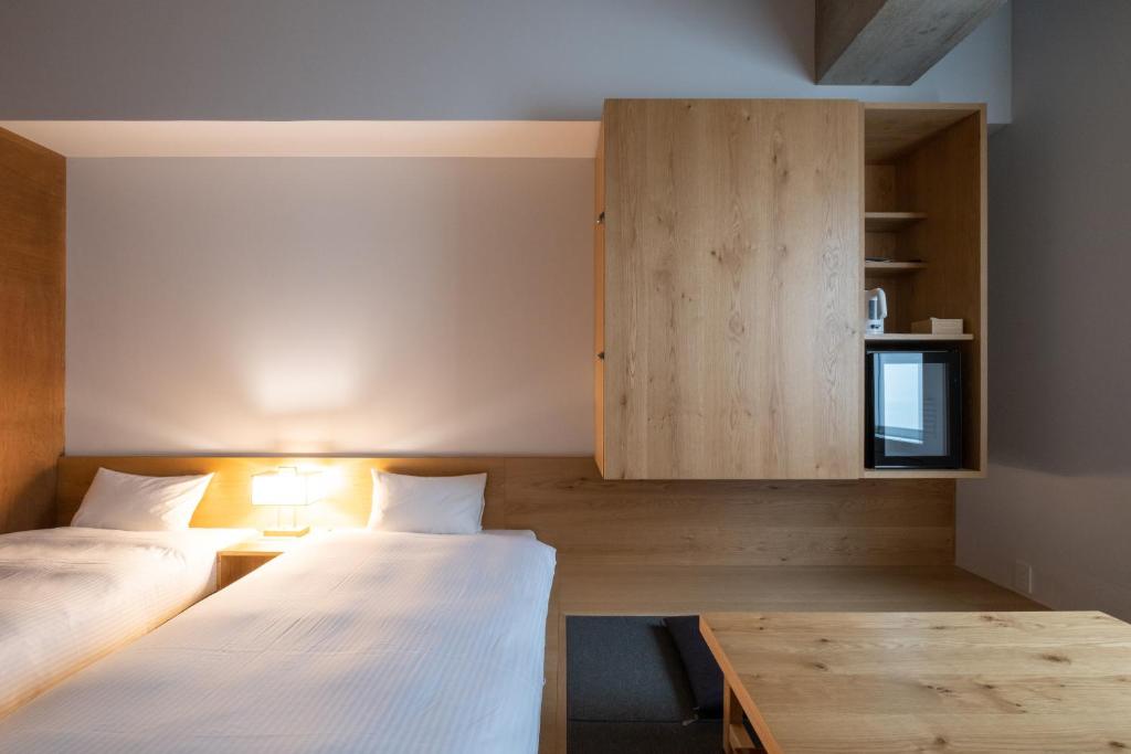 Postel nebo postele na pokoji v ubytování TSUGU Kyoto Sanjo by THE SHARE HOTELS