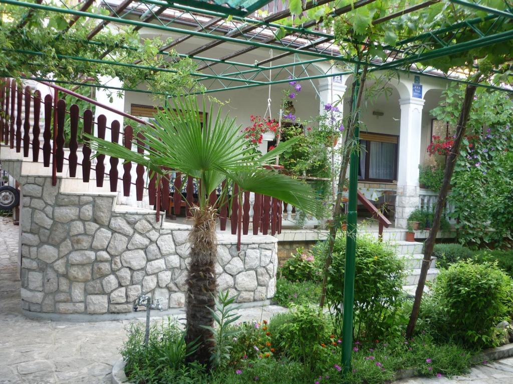 a palm tree in front of a building at Apartment Marija Selce in Selce