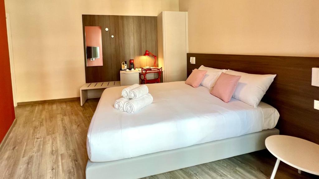 1 dormitorio con 1 cama blanca grande y 2 toallas en ARKADIA 2.0, en Cagliari