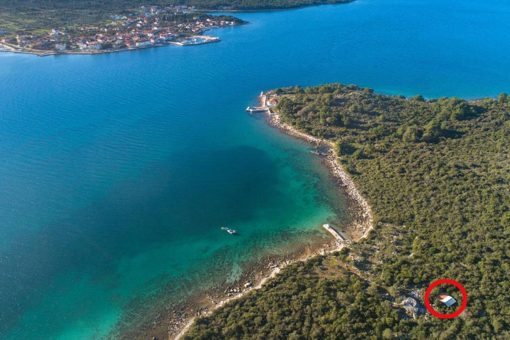an island with a red object in the water at Secluded fisherman's cottage Cove Babac, Pasman - 20901 in Pašman