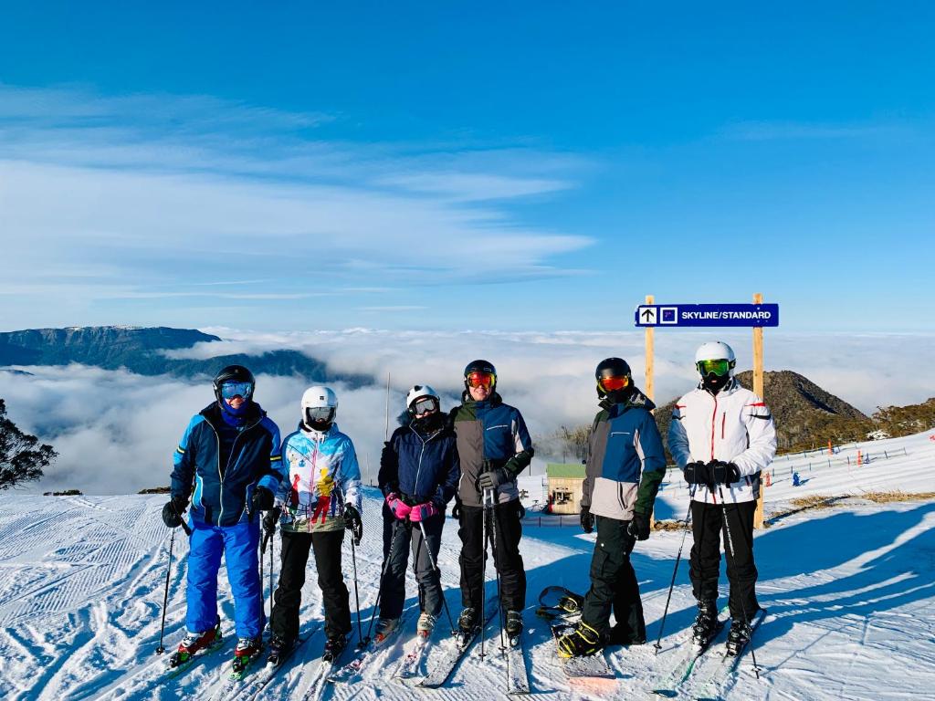 un grupo de personas de pie sobre una pista de esquí en MAGNIFICENT SKIING ON MOUNT BULLER, en Mount Buller