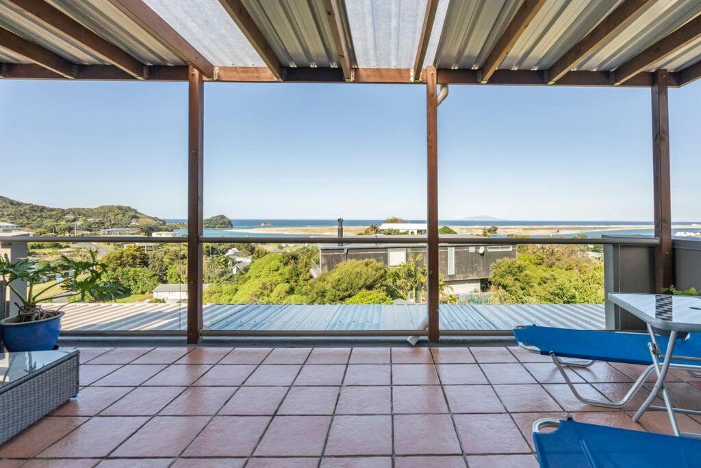 a large screened in porch with a view of the ocean at Million Dollar Views in Mangawhai