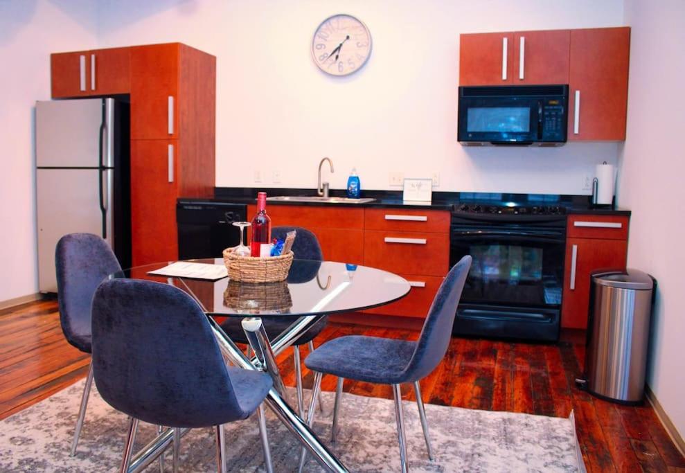 a kitchen with a table and chairs and a refrigerator at Cozy Stylish Downtown Loft in Saint Louis
