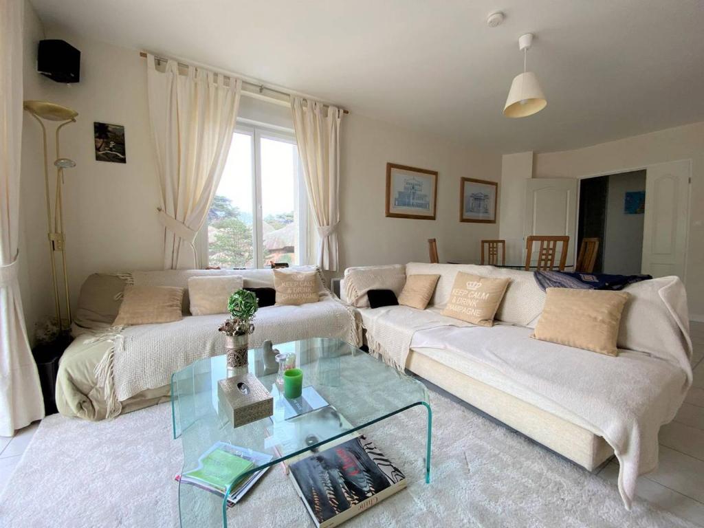 salon z białą kanapą i szklanym stołem w obiekcie Appartement spacieux face plage avec balcon, parking privé et animaux admis à Trégastel - FR-1-368-378 w mieście Trégastel