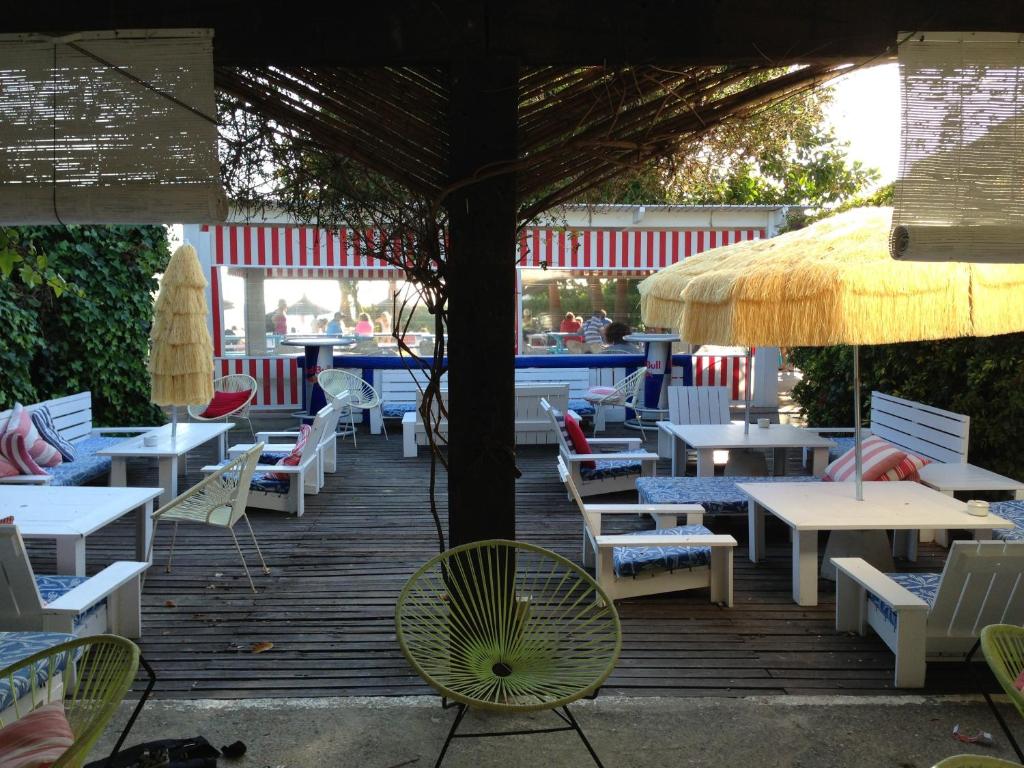 a patio with tables and chairs and an umbrella at Bungalows Tangana in Tarifa