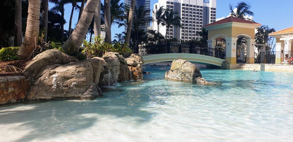 a swimming pool with a bridge in the water at Bellagio@Chevron, Luxe, 2 Bedroom Apartment in the Heart of Surfers Paradise! in Gold Coast