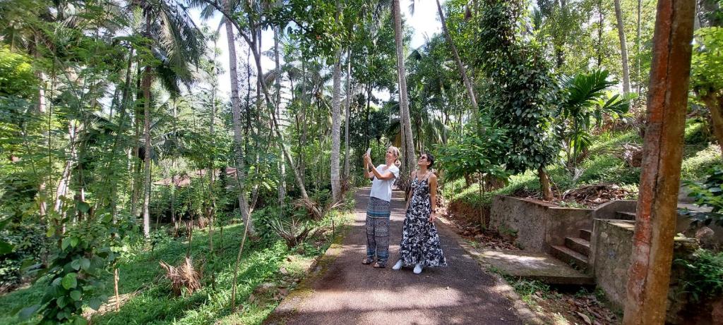 two women standing on a path in a forest at Windy Ridge Kandy in Kandy