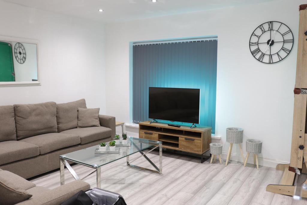 a living room with a couch and a flat screen tv at 5 Bed Town House Within City Centre and Sleeps Up To 11 with Sky and Netflix in Birmingham