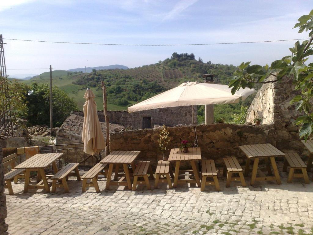 um grupo de mesas e cadeiras com guarda-sol em La Locanda Di Cadì em Petralia Soprana