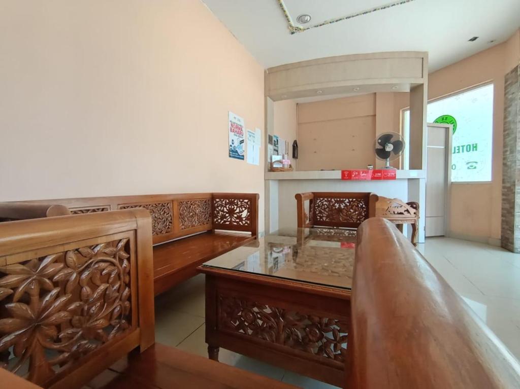 a living room with wooden furniture and a mirror at HOTEL RK CAHAYA in Labuan