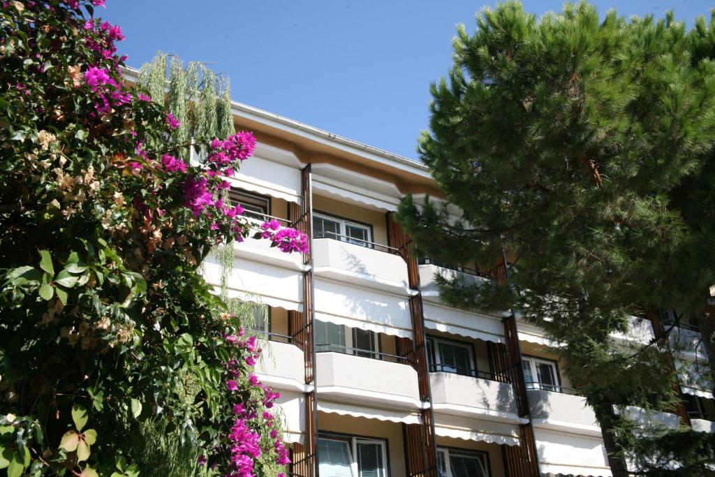 a white building with purple flowers in front of it at Hotel Palace in Varazze