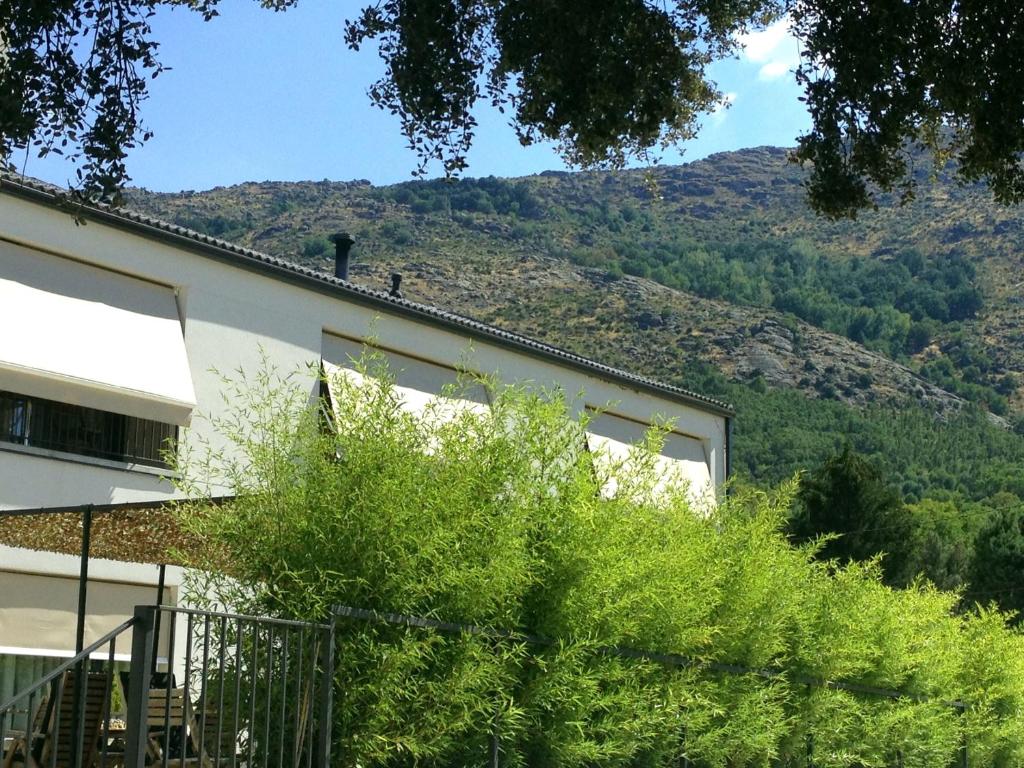 a building with a mountain in the background at El Hotelito in Navaluenga