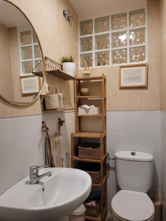 a bathroom with a sink and a toilet and a mirror at "COZY LOFT", TERRACE, PARKING and SWIMMING POOL in Málaga