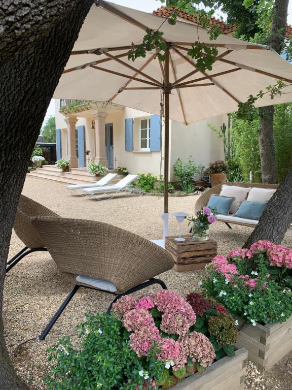 a patio with an umbrella and some flowers at La Largarde in Six-Fours-les-Plages