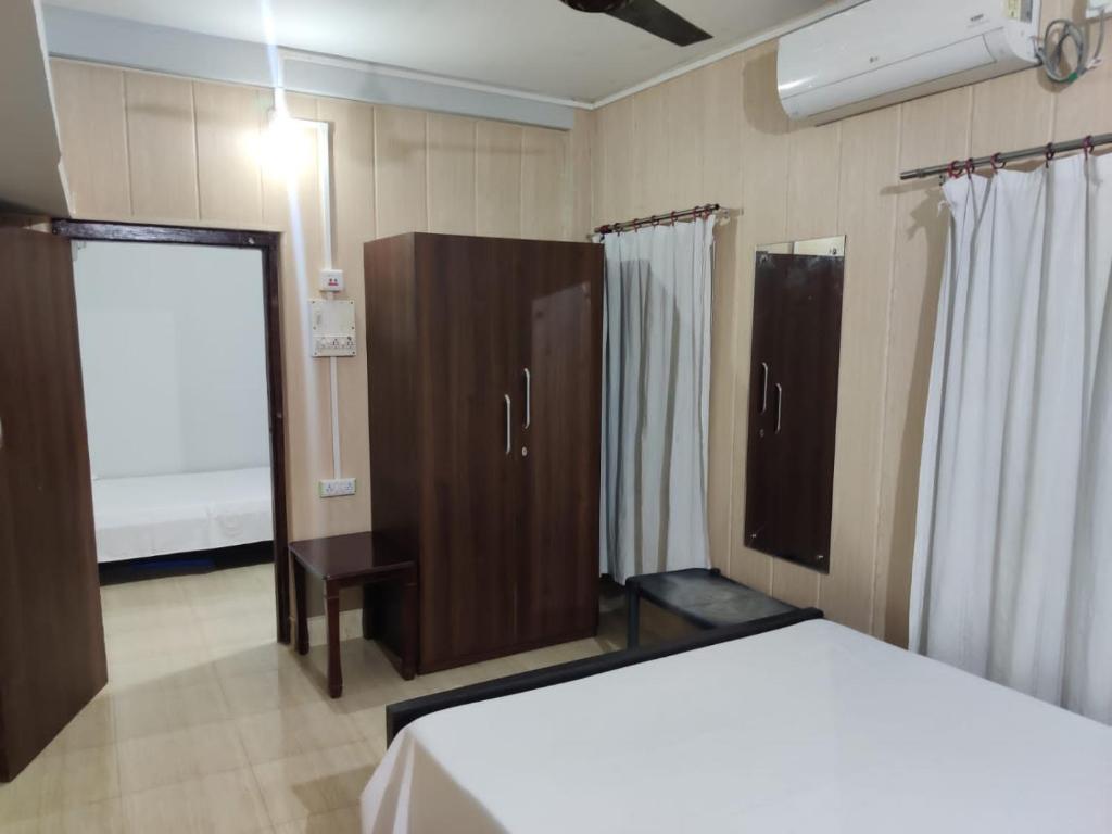 a bedroom with a bed and a cabinet and a window at Newa Service Apartment in Siliguri