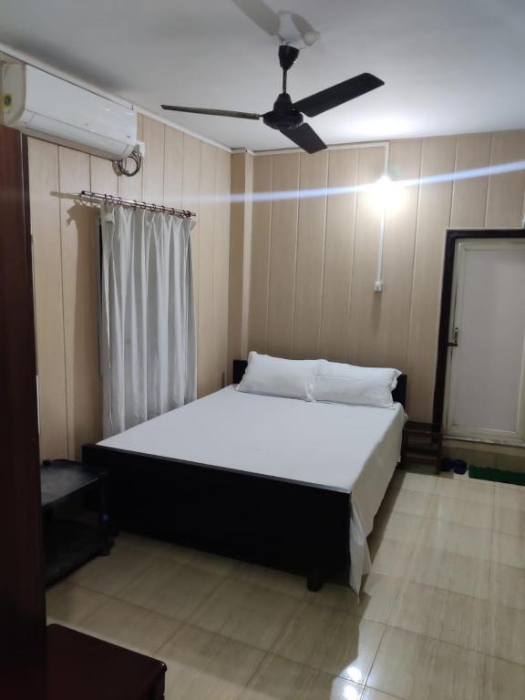 a bedroom with a bed with a ceiling fan at Newa Service Apartment in Siliguri