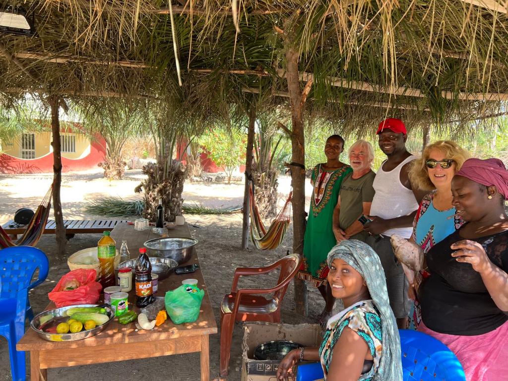 Un groupe de personnes assis sous une cabane dans l'établissement Abené shuDyma lodge, à Abémé